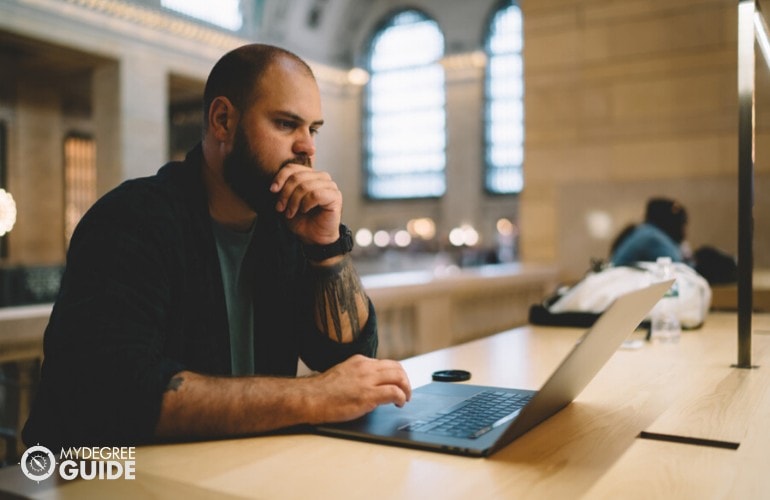 general studies degree student searching online in library