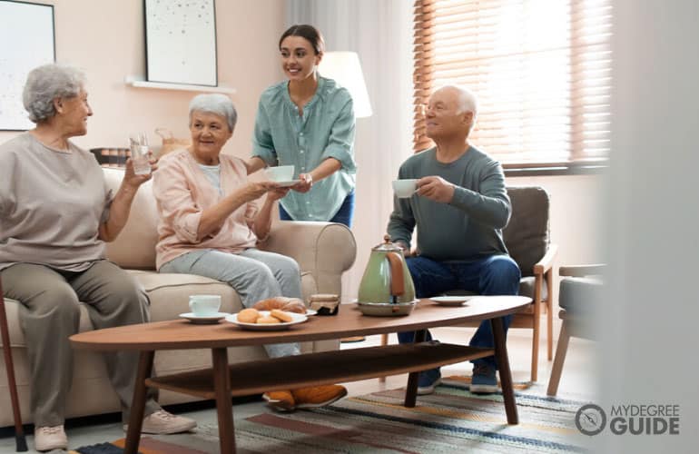 gerontologist assisting seniors with their food in a senior home