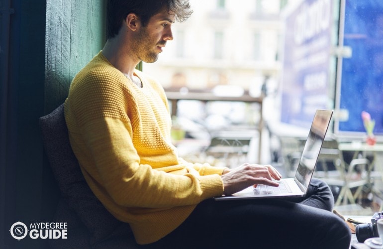 Cyber Security Degree student studying on his laptop