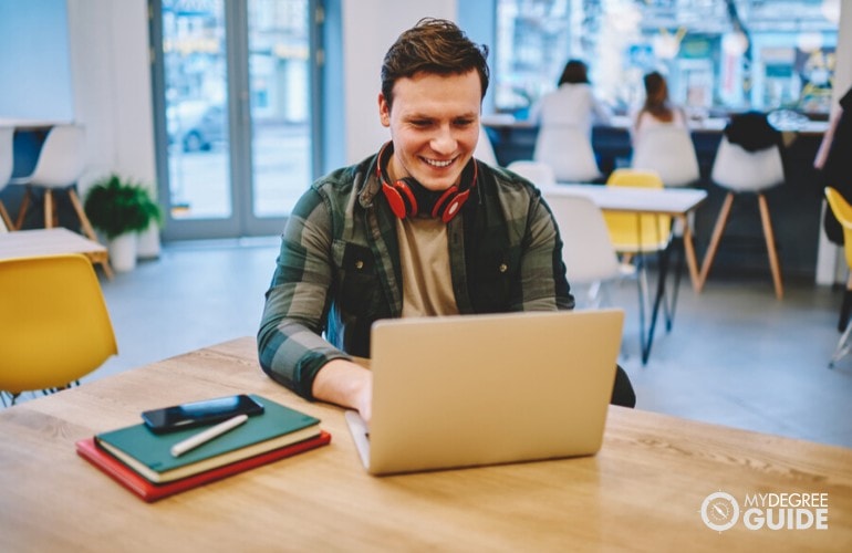 Graphic Design student studying on his laptop at a cafe