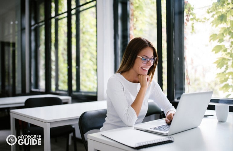 Industrial Engineering Degree student studying online at a library