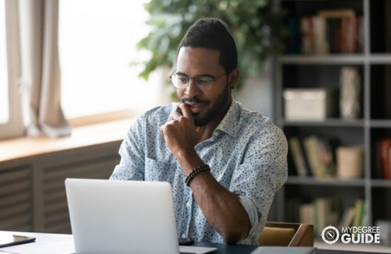 Organizational Leadership Degree student studying on his laptop at home