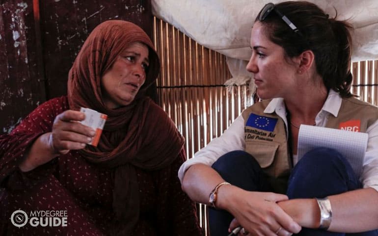 graduate social worker talking to needy woman