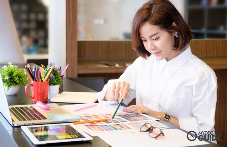 graphic designer working on her laptop in a cafe