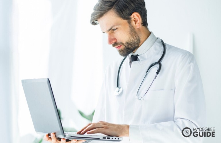 health informatics student studying on his laptop