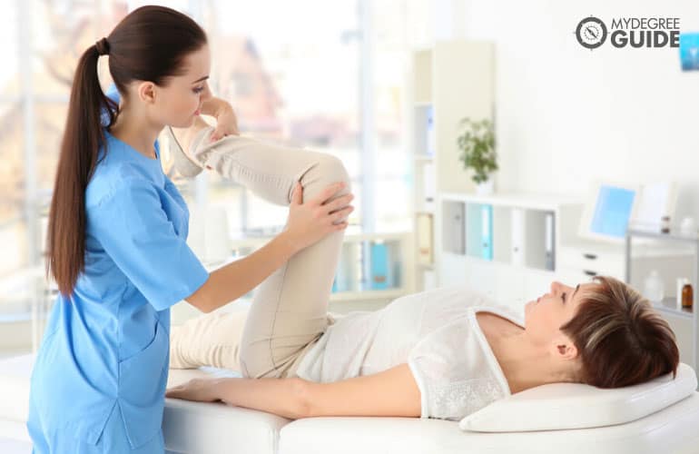 orthopedist massaging middle-aged woman in a clinic