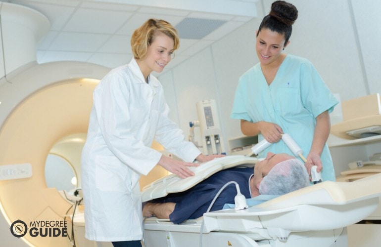 Nuclear Medicine Technologists preparing a patient for MRI