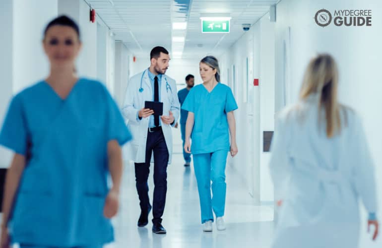 nurse and doctor talking in hospital hallway