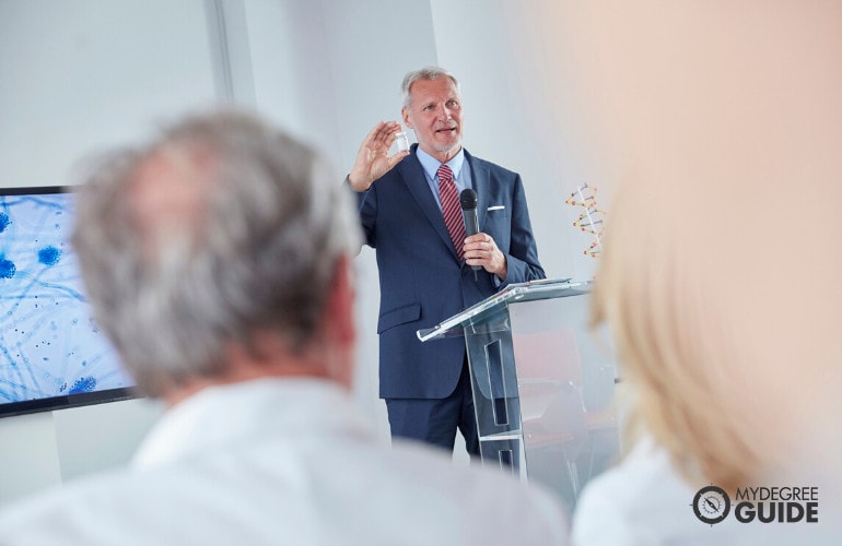 healthcare administrator speaking in front of healthcare professionals