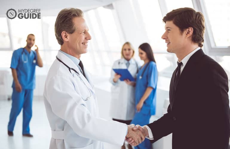 healthcare executive and phd student handshake