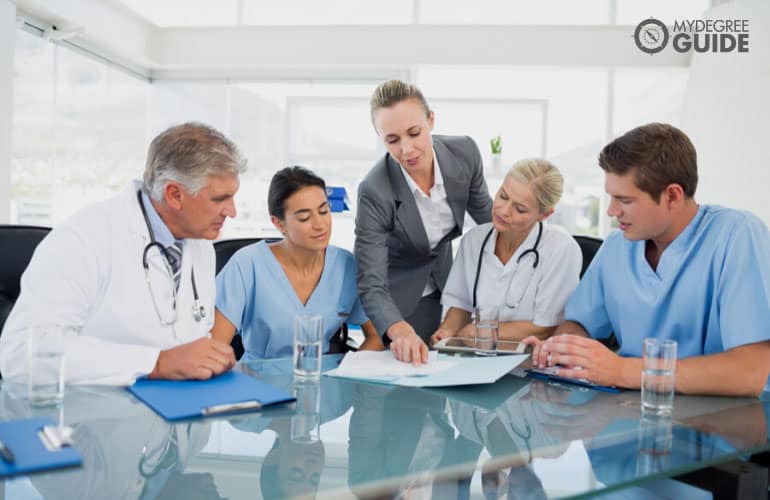 clinical director having a meeting with healthcare professionals in a hospital office