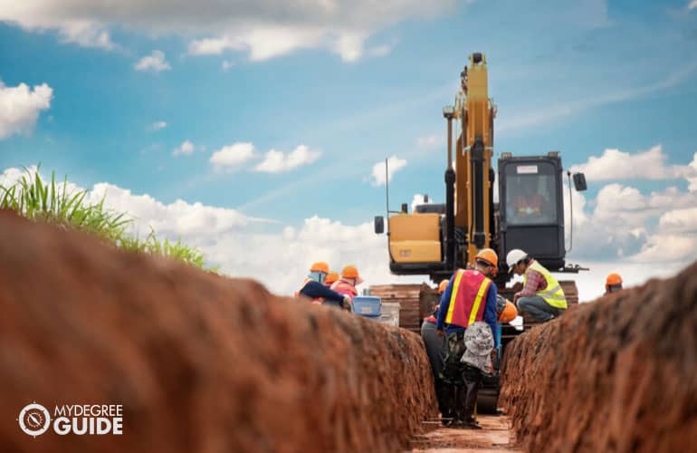 construction engineer and workers excavating water drainage at construction site