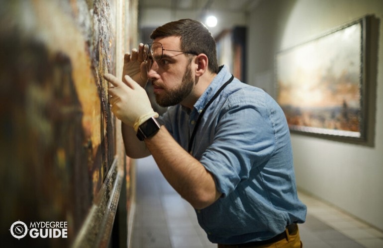 museum curator checking the paintings in a museum