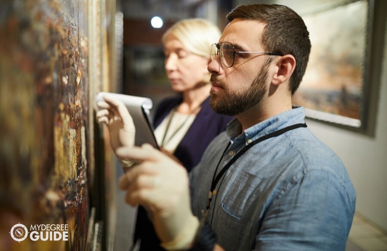 Museum Conservator checking a painting