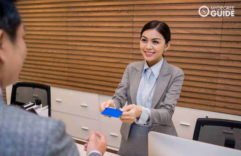 front service personnel giving key card to guest