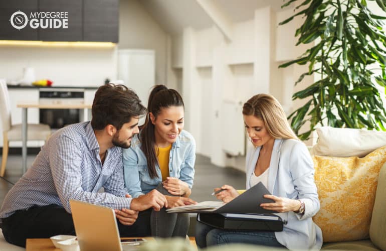 real estate agent offering home ownership to a young couple 