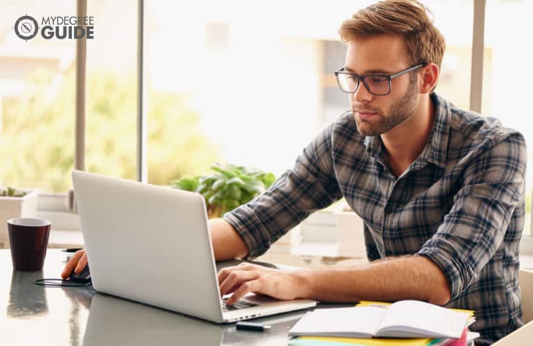 master of public health student studying on his computer