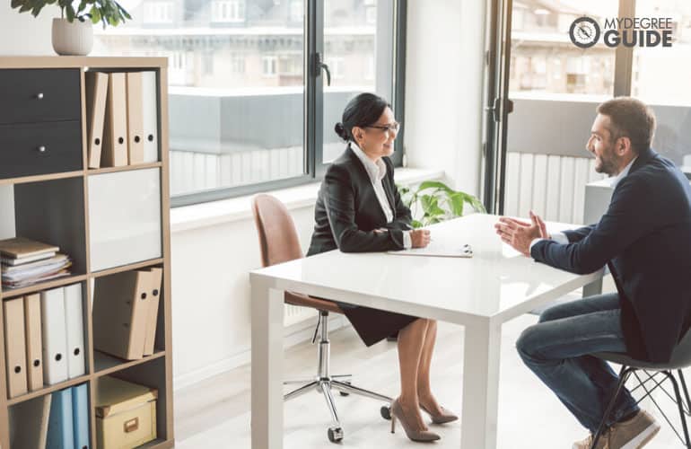 Recruitment Specialist talking to a job applicant in an office
