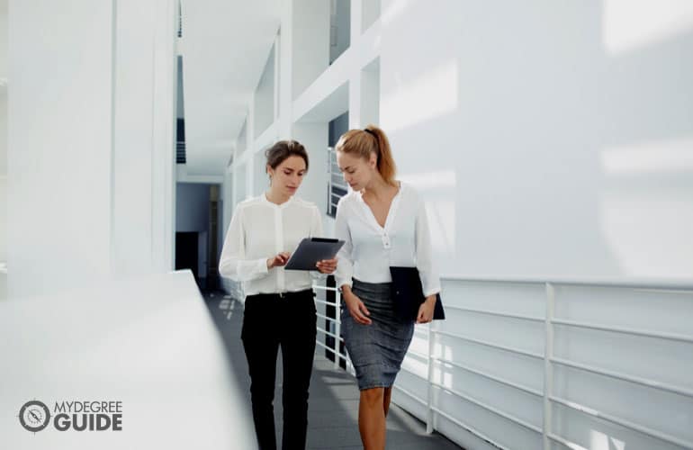 two female employees talking on the office hallway