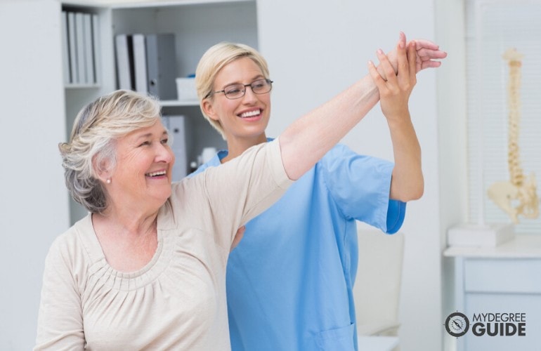 nurse helping an elderly woman during therapy