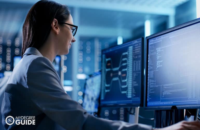 network administrator working on her computer in a data center