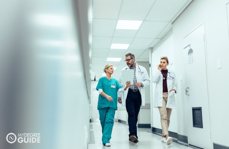 doctor giving instructions to a nurse while walking in hospital alley