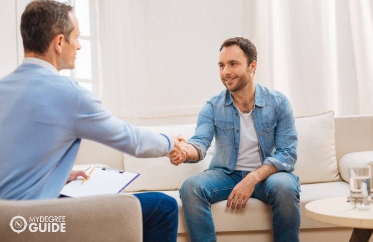 psychologist shaking hands with a patient after a therapy session