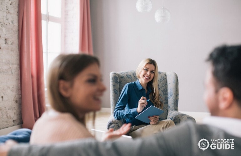 psychologist smiling during a therapy session with a couple