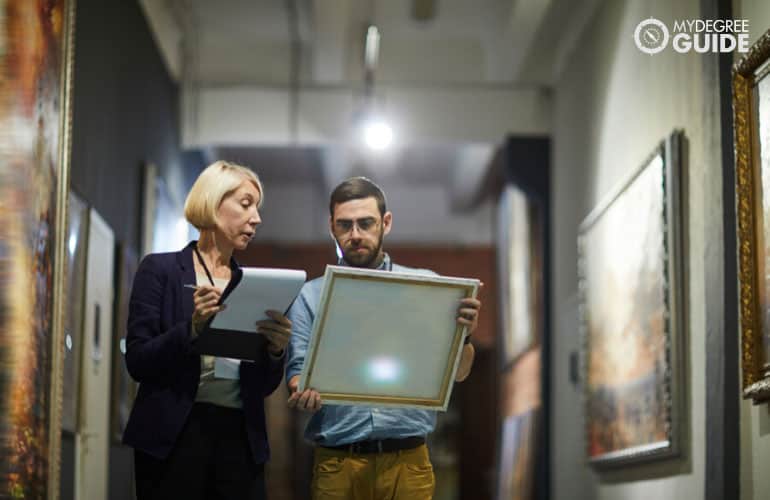 museum curators checking the paintings displayed in a museum