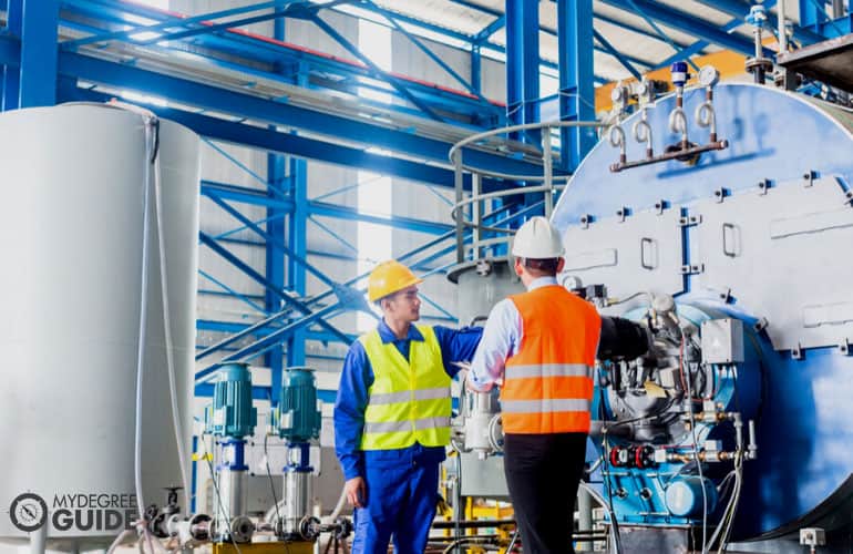 manager talking to a worker in an industrial factory