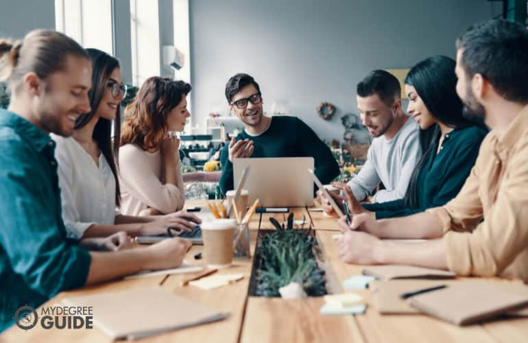 marketing manager encouraging his team to share their ideas during a meeting