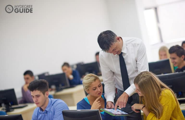 university professor assisting his students during an activity