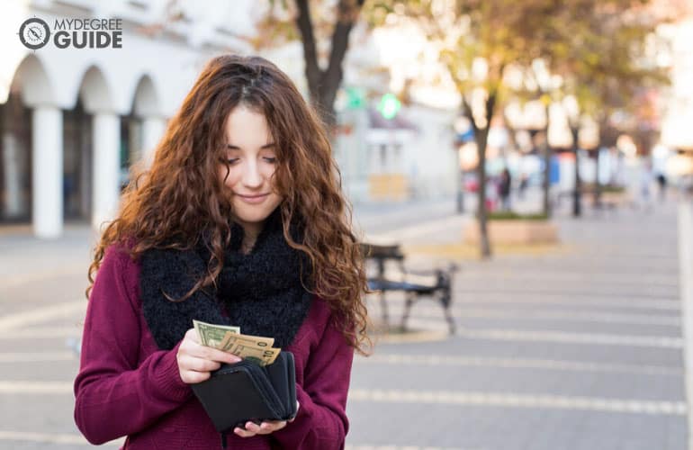 female counting money on her wallet