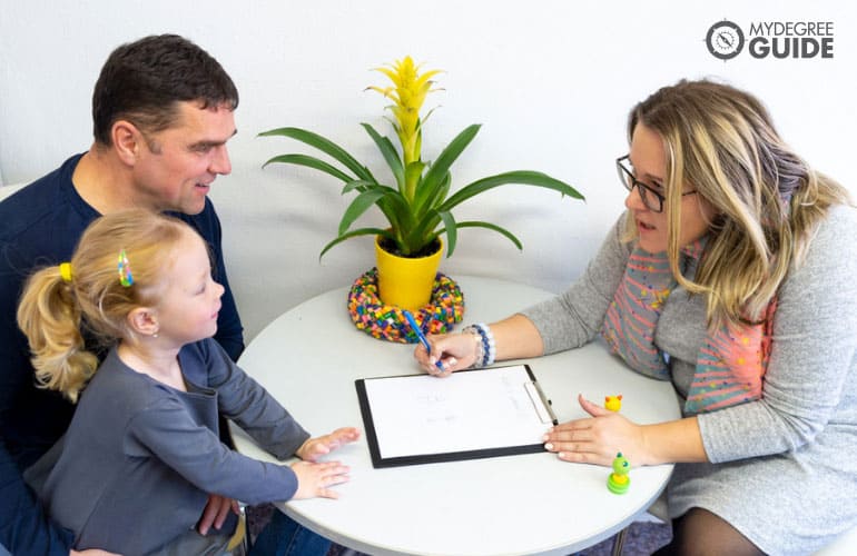 social worker talking to a young girl and her father