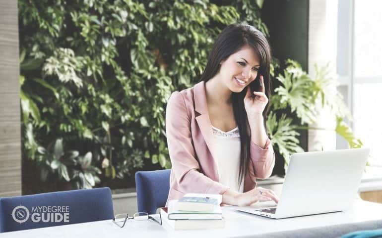 athletic sports director on phone working at laptop