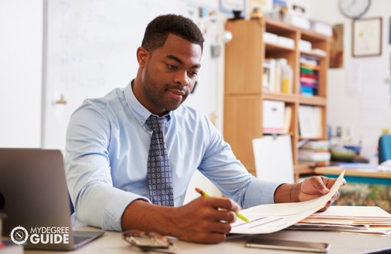 Teacher checking on documents in his office