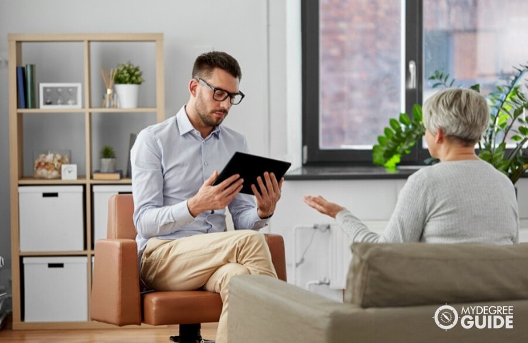 mental health counselor listening to his senior patient in his office