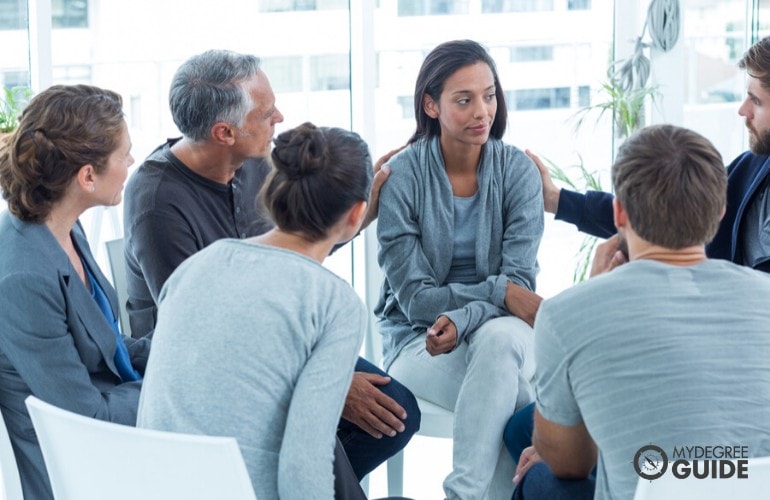 mental health counselor listening to one of the patients during group counseling