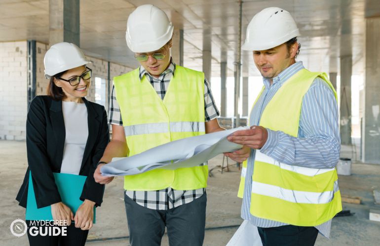 Construction Manager checking blueprint with the team