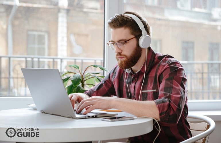 counseling degree student studying on his laptop