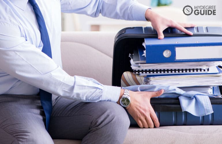 man trying to fit his things in his briefcase