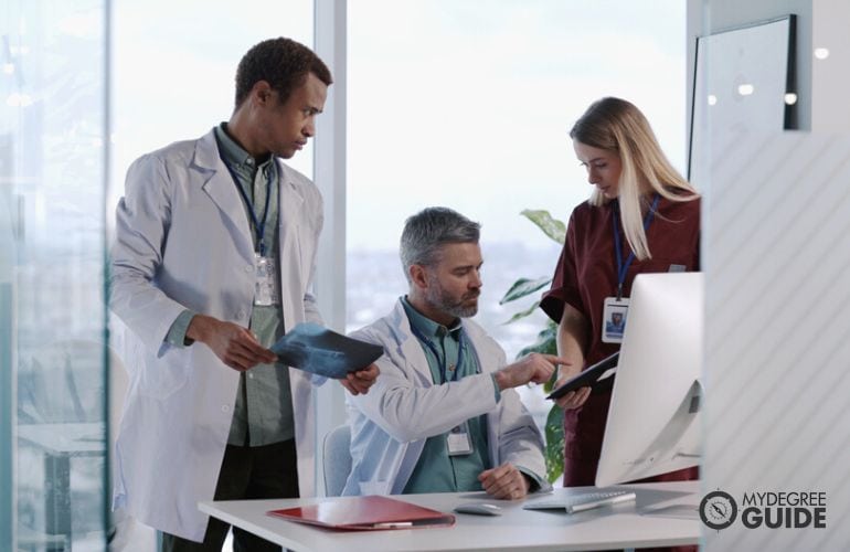 Manager in physicians’ office, discussing with staff