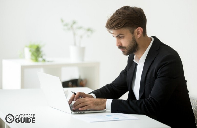 Management Analyst working on his laptop