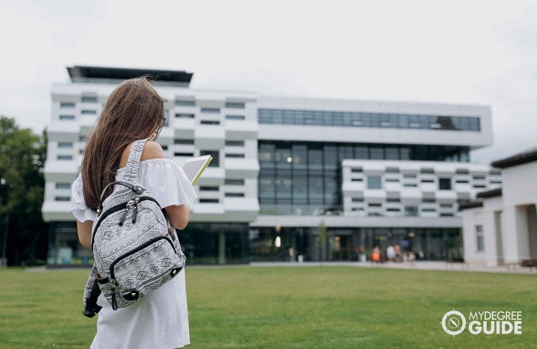 female student walking into a college building