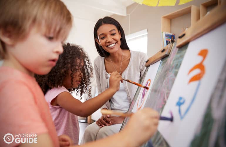 Montessori teacher letting her pupils paint during art session