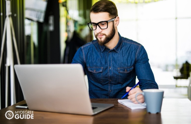 International Business student studying on his laptop at a cafe