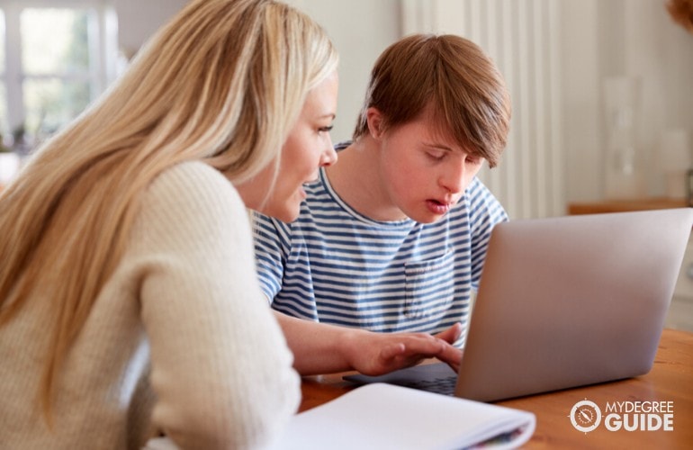 special education teacher teaching a child with down syndrome