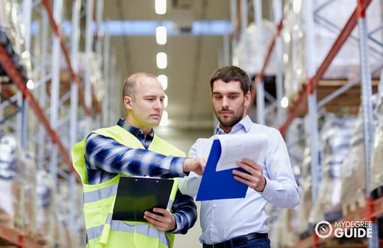 industrial production manager supervising a worker