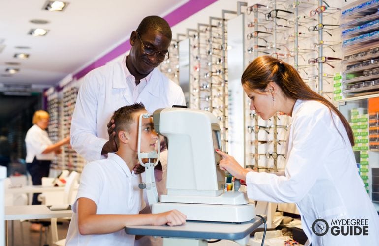 Ophthalmic Medical Assistant checking patient's vision 