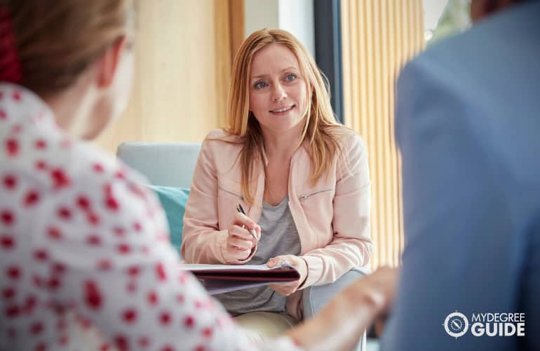 female counselor doing a therapy session with a couple in her office